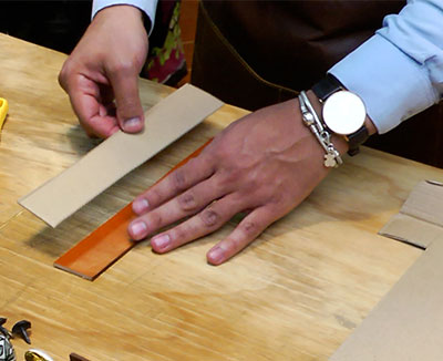 Fotografía del proceso de instalación de la jaladera de cuero en el cajón de madera